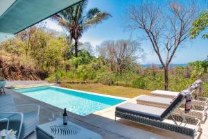 a swimming pool with a table and chairs next to a pool at Ocean View Tranquility 2BR with Pool in San Juanillo