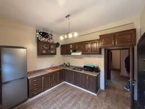 a kitchen with wooden cabinets and a stainless steel refrigerator at Villa Ama in Marrakesh