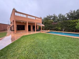 a house with a large yard and a swimming pool at Villa Ama in Marrakesh