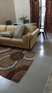 a couch sitting in a living room with a rug at Résidence Fatima in Tambacounda