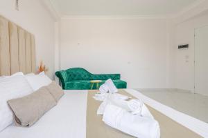 a white room with a green couch and towels at Golden Hill Ksamil in Ksamil +125 photos