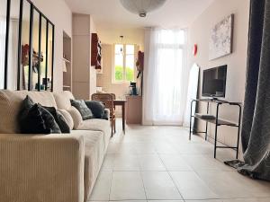 a living room with a couch and a tv at Les Appartements d Aristide Avallon in Avallon