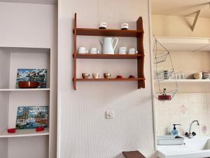a bathroom with wooden shelves next to a sink at Les Appartements d Aristide Avallon in Avallon +40 photos