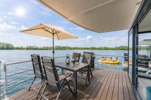 a wooden deck with a table and chairs on a boat at Floatinghouse Achat in Zehdenick