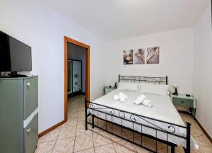 a bedroom with a bed and a flat screen tv at Popi House in Menaggio