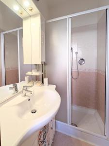 a white bathroom with a sink and a shower at Popi House in Menaggio
