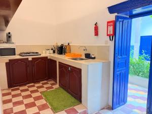 a kitchen with brown cabinets and a blue door at RiadTiznitSouss Votre oasis privée à Tiznit in Tiznit