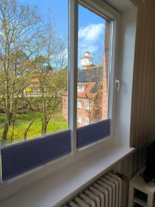 a window with a view of a building at Wind und Meer in Langeoog