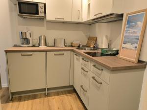 a kitchen with white cabinets and a counter top at Wind und Meer in Langeoog