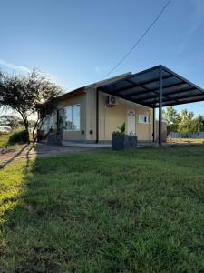 a house with a large grass field in front of it at Complejo San Carlos in General Acha