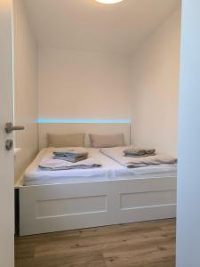 a white bed with two pillows on top of it at Wind und Meer in Langeoog