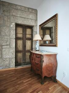 a room with a table with a lamp and a mirror at Casa do Cabo in Ribeira de Pena