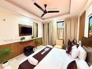 a bedroom with a large white bed and a tv at Hotel Oxygen La Vida-Noida Sector 18 in Noida