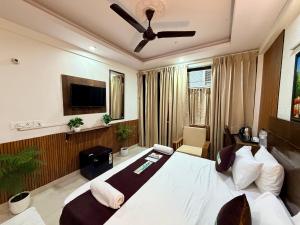 a bedroom with a large white bed and a tv at Hotel Oxygen La Vida-Noida Sector 18 in Noida