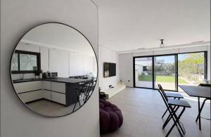 a kitchen and a living room with a mirror at villa sam in Feyzin