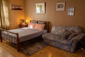 a bedroom with a bed and a couch at Unique Mailo House & Cottage in Riga