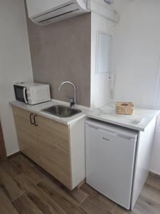 a small kitchen with a sink and a microwave at Kiriki rooms in Camas