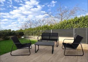 three chairs and a table on a patio at villa sam in Feyzin