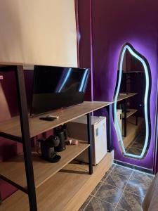 a room with a desk with a tv and a mirror at Morada do Boto in Santarém