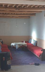 a room with two beds and a table in it at ZAZA Guest house in Agoudal