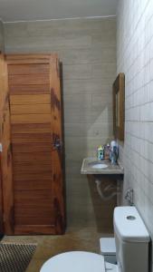 a bathroom with a toilet and a wooden door at Recanto da Julie in Mulungu +11 photos