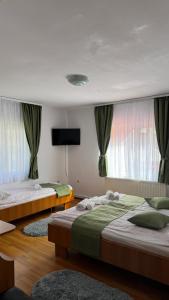 a bedroom with two beds and a flat screen tv at Casa Iuly in Gârda de Sus