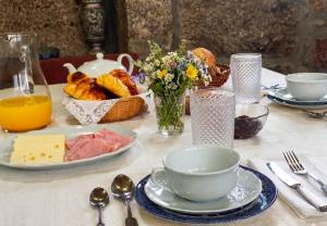 a table with a plate of food and a bowl of bread at Casa do Cabo in Ribeira de Pena