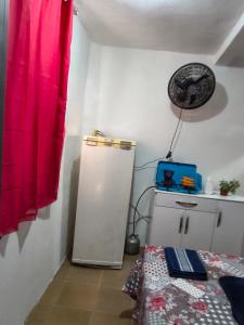 a room with a red curtain and a refrigerator at Hospedagem Campestre da Dutra 01 in Barra Mansa