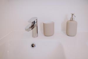 a bathroom with two white bottles and a sink at L'extension - Studio in Aussonne +11 photos