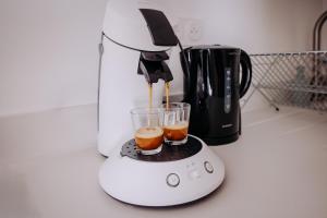 a blender sitting on a counter with two glasses of juice at L'extension - Studio in Aussonne