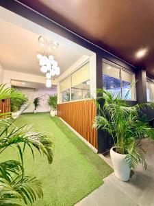 a living room with green carpet and plants at Hotel Oxygen La Vida-Noida Sector 18 in Noida