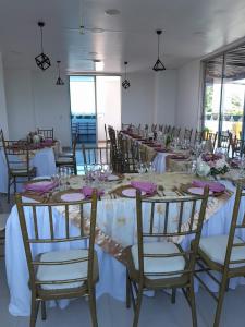 a long table in a room with tables and chairs at Hotel Ucla Center in Valledupar
