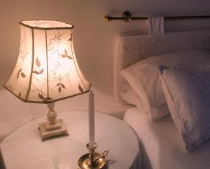 a lamp on a table next to a bed at Little Green World in Beaufort West +8 photos