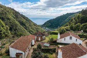 an aerial view of a village with mountains at Entre a Pedra e o Mar in Faial da Terra
