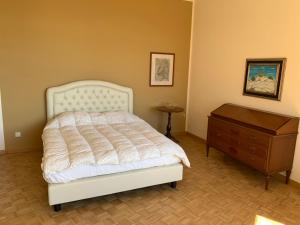 a bedroom with a white bed and a wooden dresser at La Casa di Loris in Lerici +28 photos