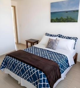 a bedroom with a blue and white bed with a picture on the wall at Villa La Blanquilla in Pampatar +12 photos