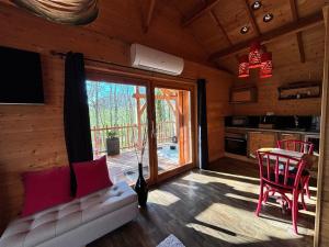 a living room with a couch and a table and a kitchen at D'EMILION De SENS in Gardegan-et-Tourtirac