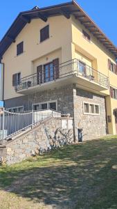 a large house with a stone wall and balcony at Dimora di Teglio in Teglio