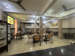 a restaurant with tables and chairs in a room at Afro-American Motel in Kampala