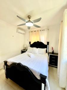 a bedroom with a large bed with a ceiling fan at Moderno Apartment Near the Ocean Santo Domingo Este Wife ,AC in La Francia