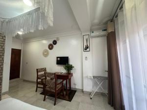 a room with a table and chairs and a television at Afro-American Motel in Kampala