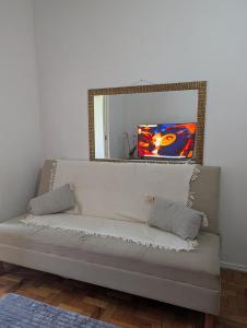 a white couch in a room with a mirror at Acomodaçao Ipanema in Rio de Janeiro