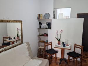a living room with a mirror and a table and chairs at Acomodaçao Ipanema in Rio de Janeiro