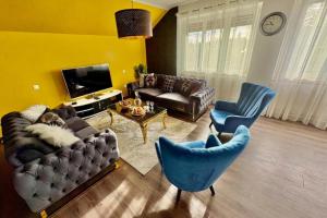 a living room with a couch and chairs and a tv at Shalhome 1 Comfort at the gates of Strasbourg in Lingolsheim