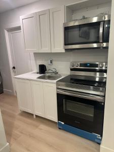 a kitchen with a stove and a sink and a microwave at Bournas Nest in Hammonds Plains +3 photos
