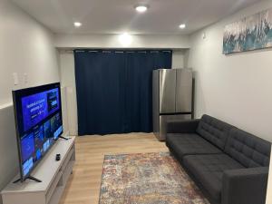 a living room with a couch and a flat screen tv at Bournas Nest in Hammonds Plains