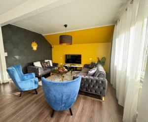 a living room with a couch and blue chairs at Shalhome 1 Comfort at the gates of Strasbourg in Lingolsheim