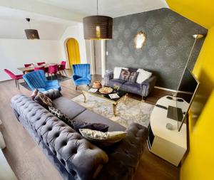 a living room with a couch and a table at Shalhome 1 Comfort at the gates of Strasbourg in Lingolsheim
