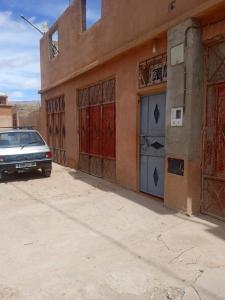 an old car parked in front of a building at Maison du Bonheur berbère in Aït Ougliff