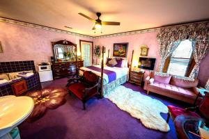 a bedroom with a bed and a bathroom with a sink at Cliff Cottage Inn, Downtown Bed & Breakfast in Eureka Springs +118 photos